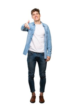 İzole beyaz arka plan üzerinde iyi bir anlaşma kapanış için el sıkışma yakışıklı bir genç adam tam uzunlukta bir çekim