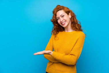Sarı kazak ile Redhead kadın doğru gülümseyerek bakarken bir fikir sunan