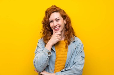 Izole sarı arka plan üzerinde Redhead kadın gülüyor