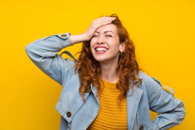 Izole sarı arka plan üzerinde Redhead kadın gülüyor