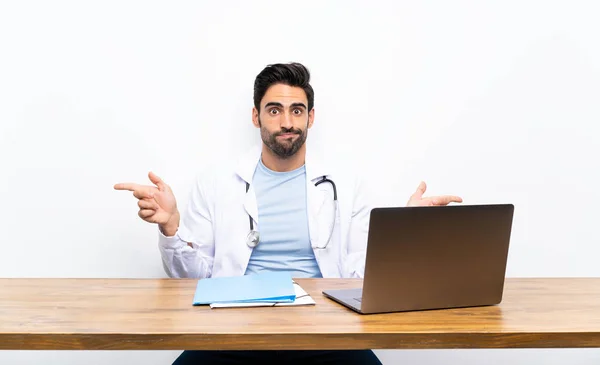 Ung Doktor Man Med Sin Laptop Över Isolerad Vägg Pekar — Stockfoto