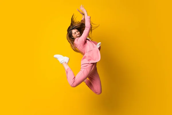 Mujer Joven Saltando Sobre Pared Amarilla Aislada —  Fotos de Stock