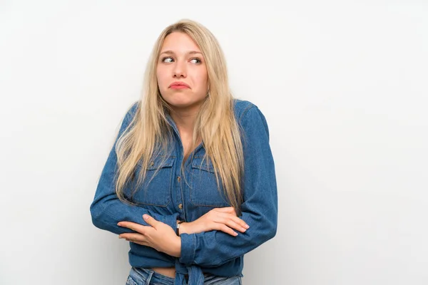 Joven Rubia Sobre Pared Blanca Aislada Haciendo Gestos Dudas Mientras —  Fotos de Stock