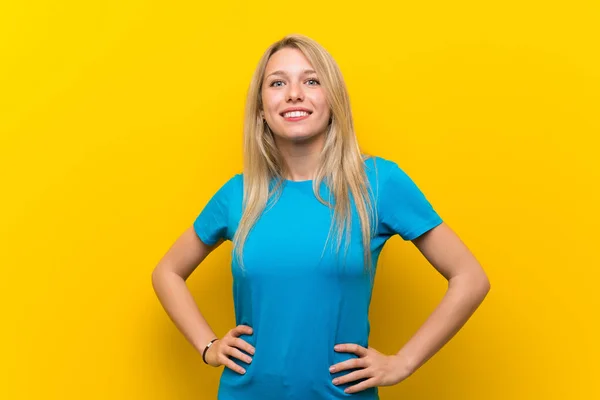 Jonge Blonde Vrouw Geïsoleerde Gele Achtergrond Poseren Met Armen Heup — Stockfoto