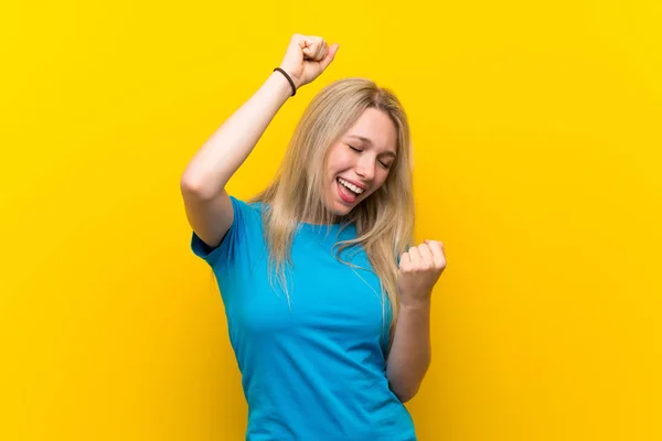 Sarışın Genç Kadın Sarı Arka Planda Zaferi Kutluyor — Stok fotoğraf
