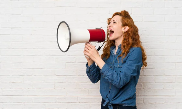 Redhead Vrouw Witte Bakstenen Muur Schreeuwen Door Een Megafone — Stockfoto