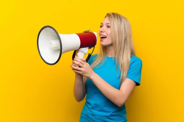 Jonge Blonde Vrouw Geïsoleerde Gele Achtergrond Schreeuwen Door Een Megafoon — Stockfoto