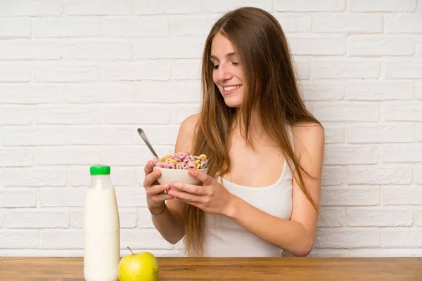 Junge Frau frühstückt mit einer Schüssel Müsli — Stockfoto