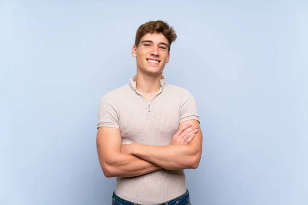 Guapo Joven Sobre Aislada Pared Azul Manteniendo Los Brazos Cruzados — Foto de Stock