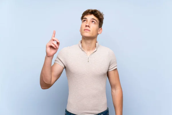 Guapo Joven Sobre Aislada Pared Azul Apuntando Hacia Arriba Sorprendido —  Fotos de Stock