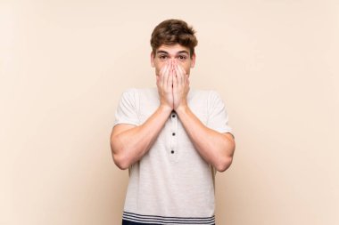 Sürpriz yüz ifade ile izole arka plan üzerinde yakışıklı genç adam