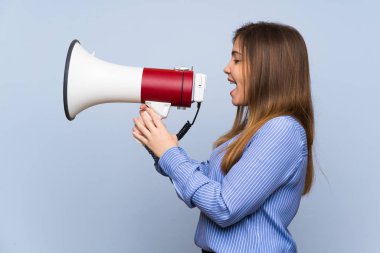 Izole mavi duvar üzerinde genç kız bir megafon ile bağırıyor