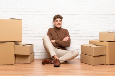 Yeni evinde kutular arasında dolaşan yakışıklı genç adam gülüyor