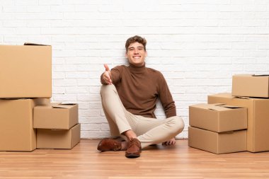 Yakışıklı genç adam iyi bir anlaşma sonra el sıkışma kutuları arasında yeni bir evde hareket