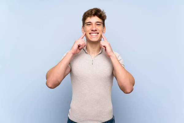 Stilig Ung Man Över Isolerad Blå Vägg Leende Med Ett — Stockfoto