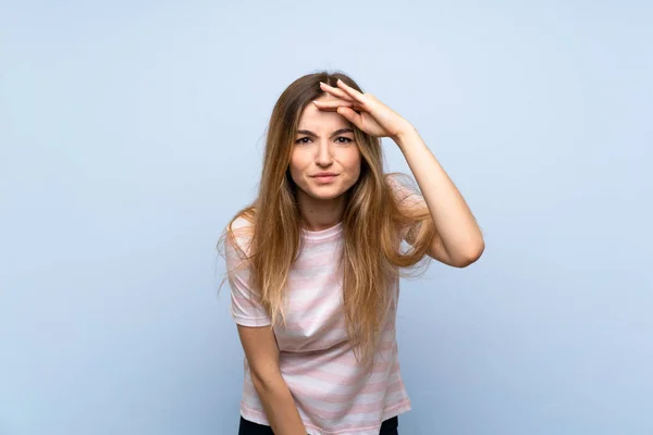 Junge Frau Über Isoliertem Blauem Hintergrund Schaut Mit Der Hand — Stockfoto