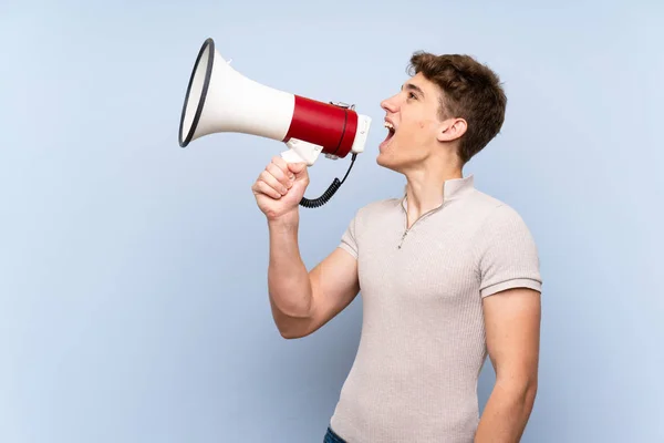 Knappe Jonge Man Geïsoleerde Blauwe Muur Schreeuwen Door Een Megafone — Stockfoto