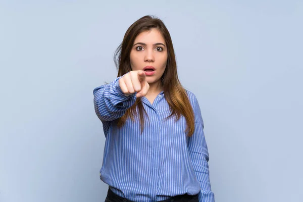 Jovencita Sobre Aislada Pared Azul Sorprendida Apuntando Frente —  Fotos de Stock