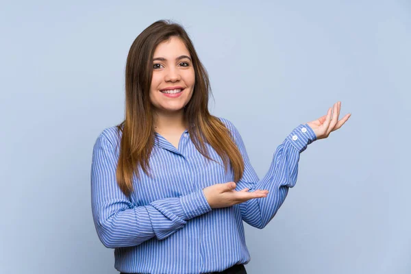 Menina Sobre Parede Azul Isolado Estendendo Mãos Para Lado Para — Fotografia de Stock