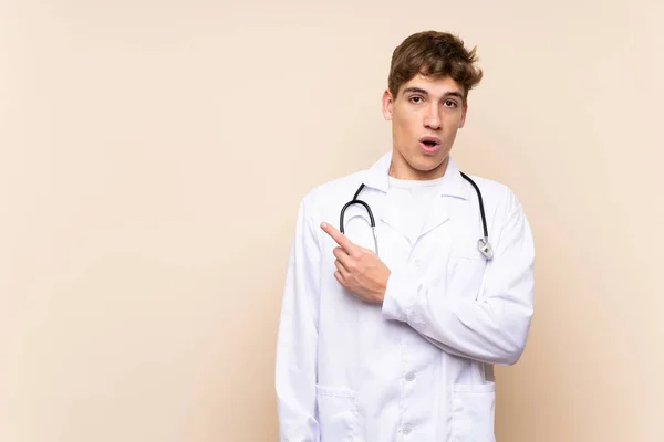 Handsome Doctor Young Man Isolated Wall Surprised Pointing Side — Stock Photo, Image