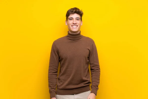 Pohledný Mladý Muž Nad Izolovaným Žlutým Pozadím Který Drží Paže — Stock fotografie