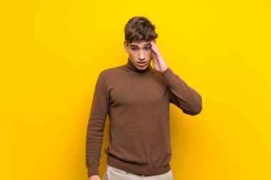Izole sarı arka plan üzerinde Yakışıklı genç adam sadece bir şey fark etti ve çözüm niyetinde