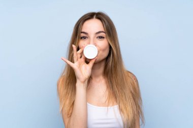 Nemlendirici ile izole mavi arka plan üzerinde genç kadın