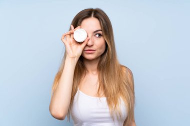 Nemlendirici ile izole mavi arka plan üzerinde genç kadın