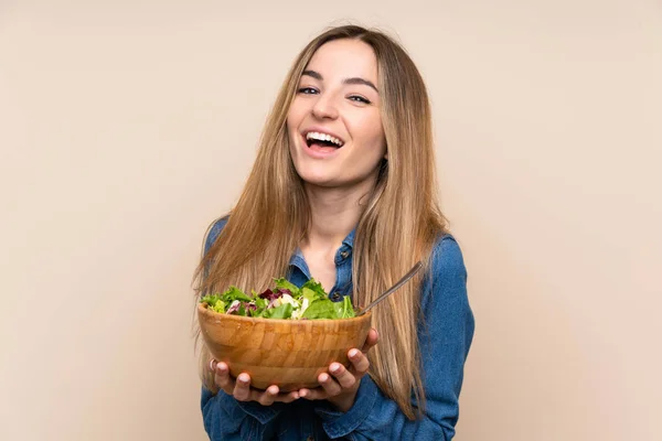 Young woman with salad over isolated background