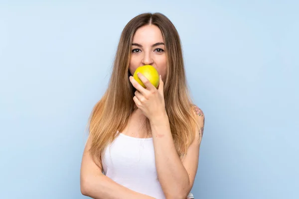 リンゴと孤立した青い背景の上の若い女性 — ストック写真