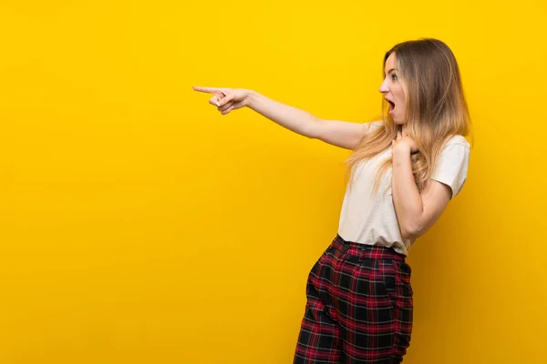 Jovem Mulher Sobre Isolado Amarelo Parede Apontando Dedo Para Lado — Fotografia de Stock