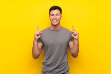 Izole sarı duvar üzerinde Yakışıklı adam harika bir fikir işaret