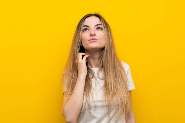 Jovem Mulher Sobre Isolado Parede Amarela Pensando Uma Ideia — Fotografia de Stock