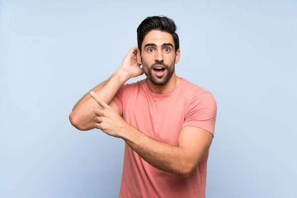 Hombre Joven Guapo Camisa Rosa Sobre Fondo Azul Aislado Sorprendido — Foto de Stock