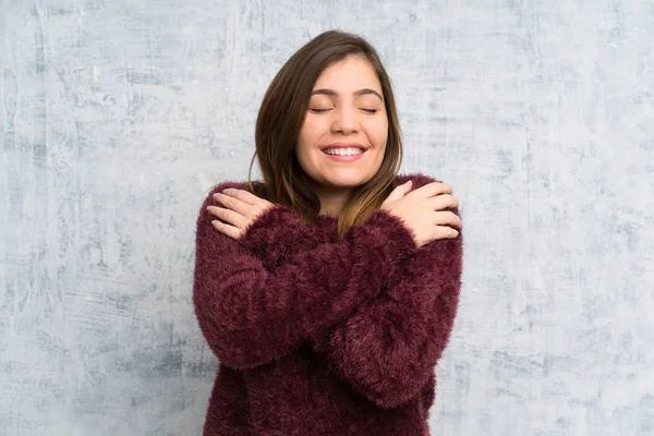 Grunge duvar üzerinde genç kız sarılma