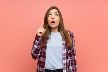 Pembe duvar üzerinde genç kız işaret ve şaşırttı