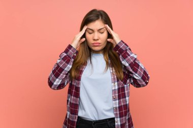 Baş ağrısı ile pembe duvar üzerinde genç kız