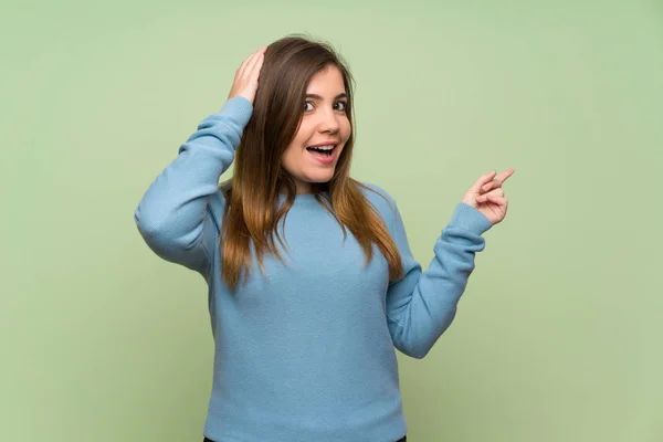 Chica Joven Sobre Pared Verde Sorprendido Señalando Dedo Lado — Foto de Stock