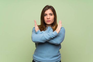 Yeşil duvar üzerinde hiçbir jest yapıyor genç kız