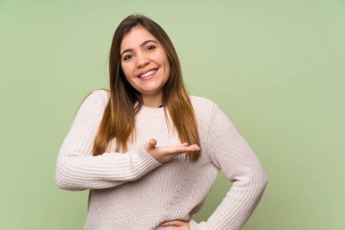 Beyaz kazak ile genç kız gelmeye davet için yan ellerini uzatıyor