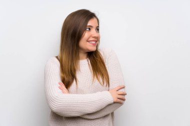 Beyaz kazak ayakta ve yan bakıyor genç kız