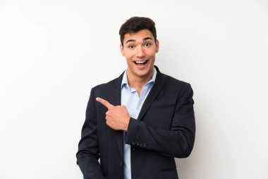 İzole beyaz duvar üzerinde yakışıklı adam tarafına parmak işaret