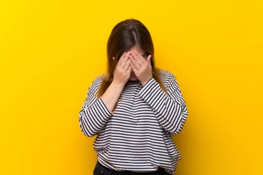 Yorgun ve hasta ifade ile sarı duvarın üzerinden genç kız