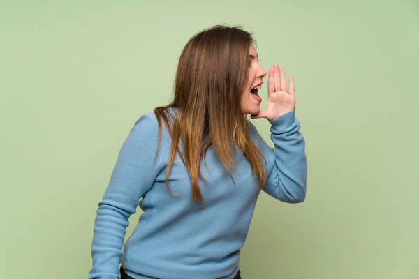 Yeşil Duvar Üzerinde Genç Kız Yanal Açık Ağız Ile Bağırıyor — Stok fotoğraf