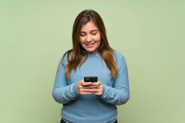 Молода Дівчина Над Зеленою Стіною Надсилає Повідомлення Мобільним — стокове фото