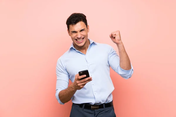 Hombre Guapo Sobre Fondo Rosa Con Teléfono Posición Victoria —  Fotos de Stock