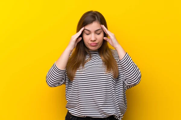 Baş ağrısı ile sarı duvar üzerinde genç kız