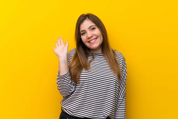 Νεαρό Κορίτσι Πάνω Από Κίτρινο Τοίχο Χαιρετούν Χέρι Χαρούμενη Έκφραση — Φωτογραφία Αρχείου