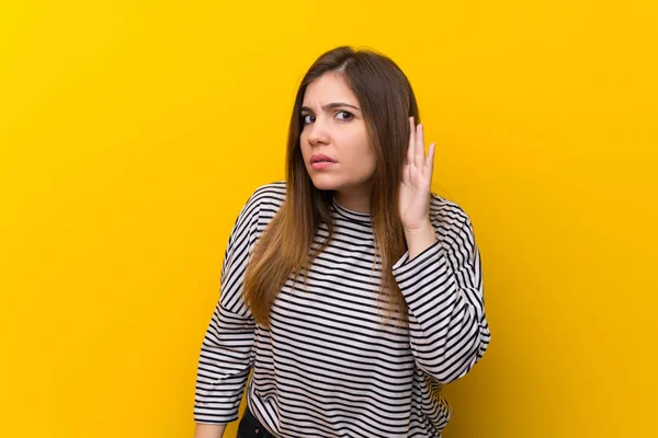 Fiatal Lány Hallgat Valami Azáltal Hogy Kezét Fül Sárga Falon — Stock Fotó