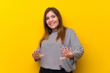 Sarı duvar üzerinde gülümseyen genç kız